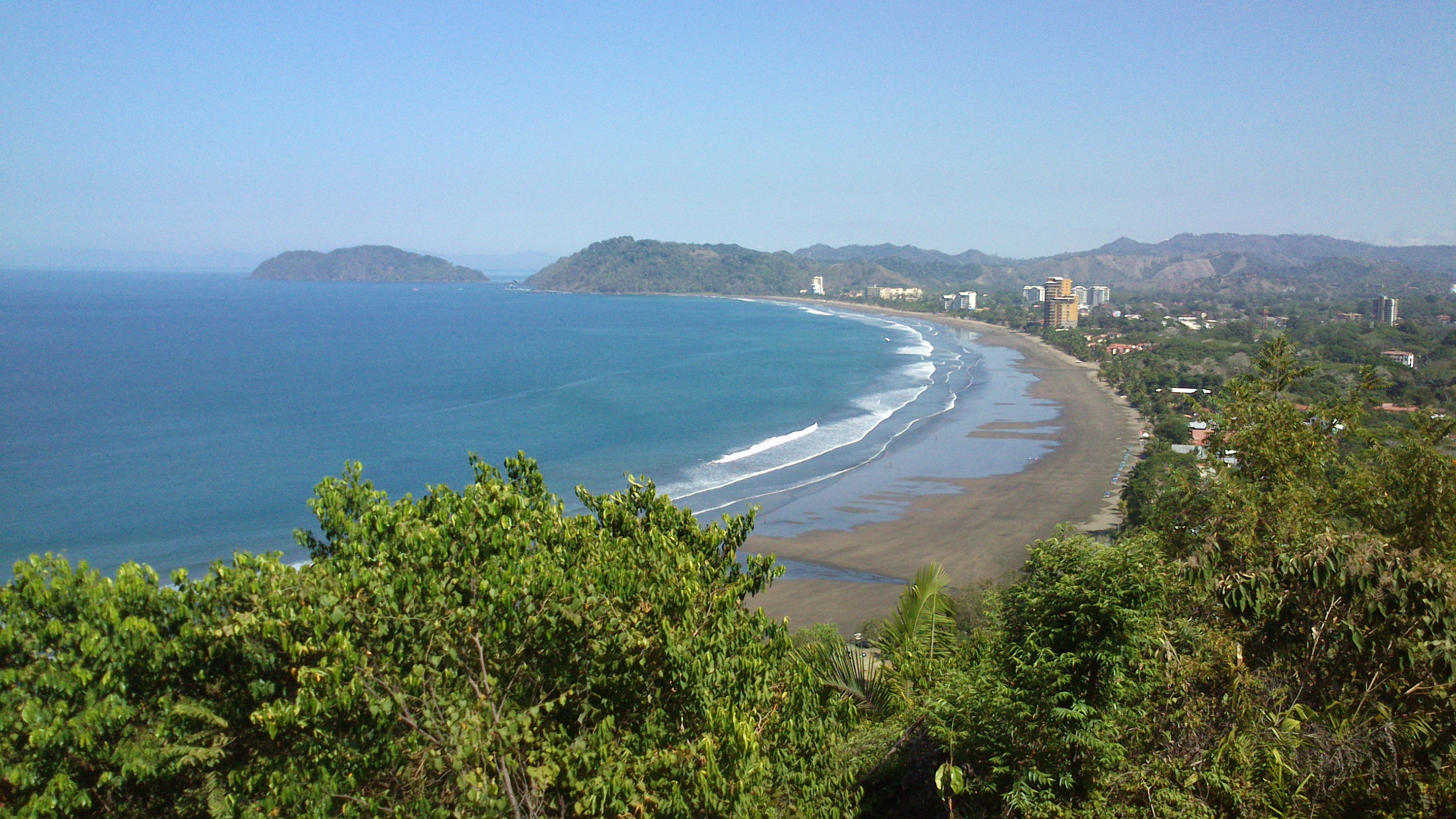 Playa Jacó from the hills, a long curve of sand and Pacific surf