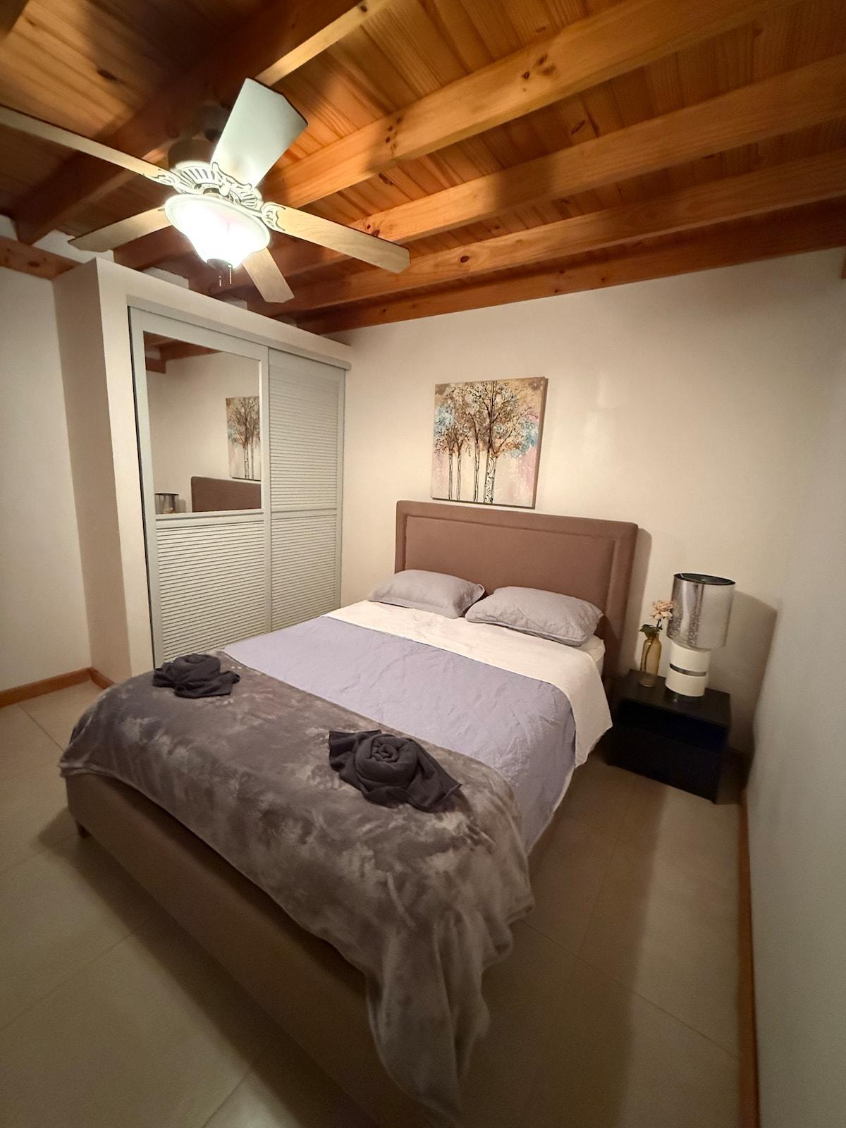 Queen bedroom with a wood-beamed ceiling and a mirrored closet
